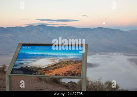 Death Valley National Park, Kalifornien, USA. Blick im Mondlicht über das Badwater Basin von Dantes Ansicht, Morgengrauen, Informationschild im Vordergrund. Stockfoto