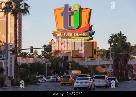 Las Vegas, Nevada, USA. Blick über den Strip auf das farbenfrohe Neonschild, auf dem das Treasure Island Hotel and Casino und der Sonnenuntergang zu sehen sind. Stockfoto