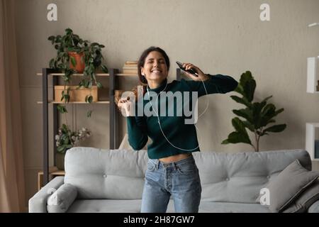 Aufgeregt junge Frau springen durch Musik vom Handy im Headset Stockfoto