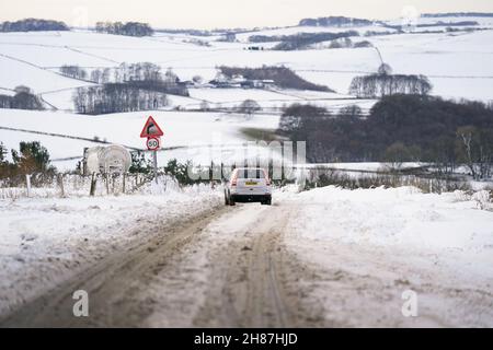 Fahrzeuge versuchen, auf der schneebedeckten A515 in der Nähe von Biggin im Peak District, Derbyshire, unter eisigen Bedingungen nach dem Sturm Arwen zu fahren. Bilddatum: Sonntag, 28. November 2021. Stockfoto