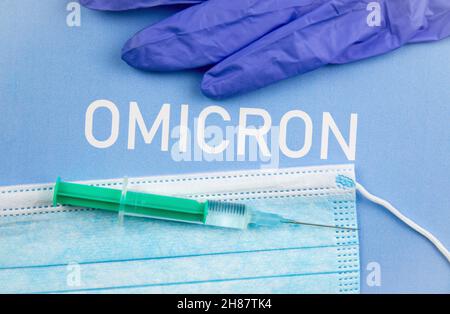 Neues Coronavirus Covid-19 Mutation Omicron Konzept. Medizinische Maske, Spritze und Text mit den Buchstaben Omicron. Stockfoto