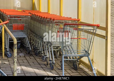 Reihen von Einkaufswagen in der Nähe des Eingangs zum Supermarkt Stockfoto