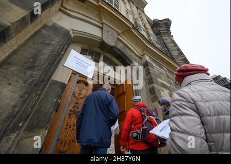 28. November 2021, Sachsen, Dresden: Menschen stehen vor der Frauenkirche, um sich bei einer Impfkampagne in der Unterkirche gegen das Coronavirus impfen zu lassen. Mit einer einzigartigen Impfkampagne in Kooperation mit dem Deutschen Roten Kreuz (DRK) zum ersten Advent wollen die sächsischen Kirchen Ärzte und mobile Teams dabei unterstützen, die Bevölkerung gegen Covid-19 zu impfen. Foto: Robert Michael/dpa-Zentralbild/dpa Stockfoto