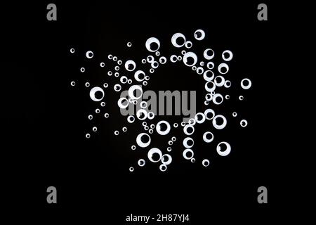 Googly Augen Kunststoff-Spielzeug auf schwarzem Hintergrund Stockfoto