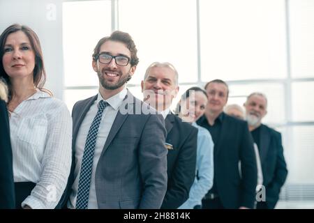 Nahaufnahme. Eine Gruppe von glücklichen Mitarbeitern steht einer nach dem anderen. Stockfoto