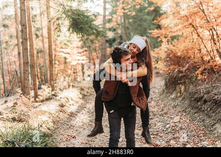 Junges romantisches Paar im Wald. Huckepack Reiten. Glücklich zusammen Stockfoto