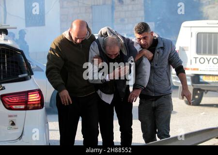 Westufer, Nablus, Palästina. 28th. November 2021. Israelische Truppen feuern Tränengas auf Schüler und ihre Familien, nachdem die Straße, die zu den Schulen führte, von israelischen Siedlern im Dorf Al-Lubban Al-Sharqiah, südlich der Stadt Nablus im Westjordanland, gesperrt wurde. Kredit: Nasser Ishtayeh/ZUMA Wire/Alamy Live Nachrichten Stockfoto