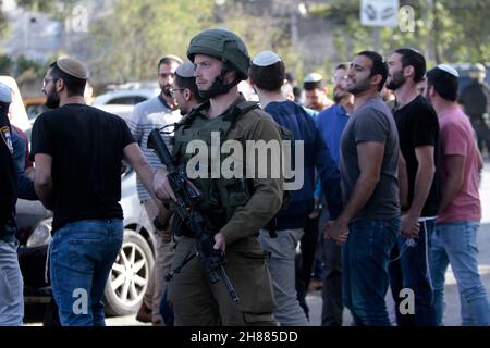 Westufer, Nablus, Palästina. 28th. November 2021. Siedler, die unter dem Schutz der israelischen Armee stehen, schließen die Straße, die zur Schule des Dorfes Al Luban Al Sharqiah südlich von Nablus im besetzten Westjordanland führt. Kredit: Nasser Ishtayeh/ZUMA Wire/Alamy Live Nachrichten Stockfoto