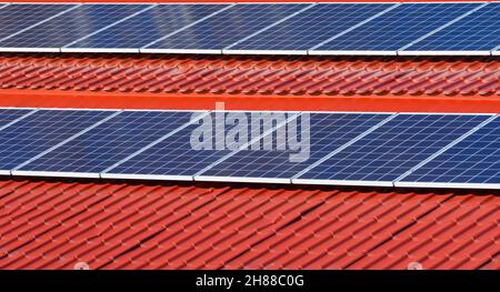 Sonnenkollektoren auf rotem Zinndach, Finnland Stockfoto