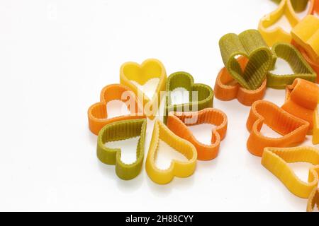 Rote, weiße, grüne Pasta in Herzform auf weißem Hintergrund. Lebensmittelkonzept. Stockfoto