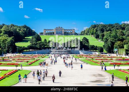 Wien, Österreich - 9. August 2011 : Blick auf den schönen Schlossgarten Schönbrunn mit Gloriette und Neptunbrunnen im Hintergrund und Touristen walki Stockfoto