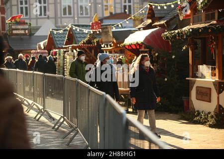 28. November 2021, Sachsen-Anhalt, Quedlinburg: Menschen besuchen den eingezäunten Weihnachtsmarkt in der Adventsstadt Quedlinburg. Der Weihnachtsmarkt gehört zu insgesamt zwei Märkten unter besonders hohen Corona-Bedingungen im Landkreis Harz haben eine Freilassungserlaubnis erhalten. Foto: Matthias Bein/dpa-Zentralbild/dpa Stockfoto