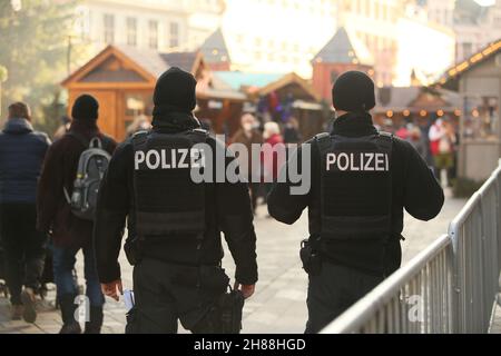 28. November 2021, Sachsen-Anhalt, Quedlinburg: Polizeibeamte checken auf dem Weihnachtsmarkt in der Adventsstadt Quedlinburg. Der Weihnachtsmarkt gehört zu insgesamt zwei Märkten unter besonders hohen Corona-Bedingungen im Landkreis Harz haben eine Freilassungserlaubnis erhalten. Foto: Matthias Bein/dpa-Zentralbild/dpa Stockfoto