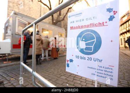 Quedlinburg, Deutschland. 28th. November 2021. An einem Zaun vor dem eingezäunten Weihnachtsmarkt in der Adventstadt Quedlinburg sind Schilder mit Hinweis auf die Maskenpflicht angebracht. Der Weihnachtsmarkt gehört zu insgesamt zwei Märkten unter besonders hohen Corona-Bedingungen im Landkreis Harz haben eine Freilassungserlaubnis erhalten. Quelle: Matthias Bein/dpa-Zentralbild/dpa/Alamy Live News Stockfoto