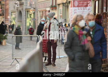 Quedlinburg, Deutschland. 28th. November 2021. Die Menschen besuchen den umzäunten Weihnachtsmarkt in der Adventstadt Quedlinburg. Der Weihnachtsmarkt gehört zu insgesamt zwei Märkten unter besonders hohen Corona-Bedingungen im Landkreis Harz haben eine Freilassungserlaubnis erhalten. Quelle: Matthias Bein/dpa-Zentralbild/dpa/Alamy Live News Stockfoto