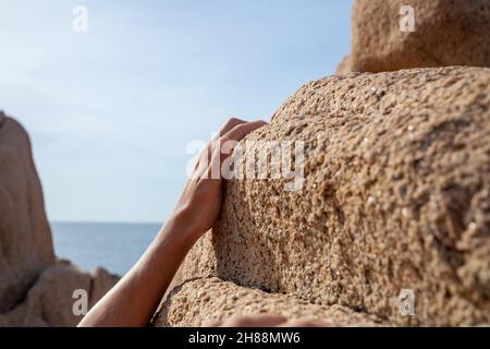 Mann, der auf einem Sandsteinberg in der Natur klettert Stockfoto