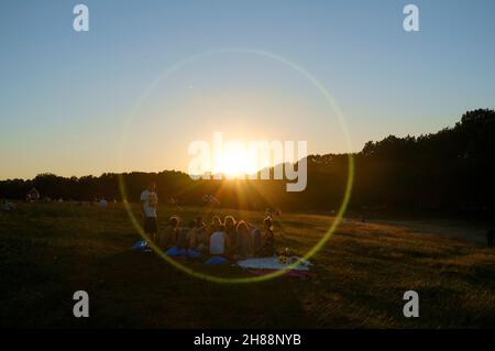 Leute, die ein Picknick machen, Hampstead Heath bei Sonnenuntergang. Hampstead Heath, London, Großbritannien. 23. Juli 2012 Stockfoto
