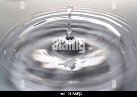Wassertropfen fallen ins Wasser macht einen perfekten Droplet-Sprung Stockfoto