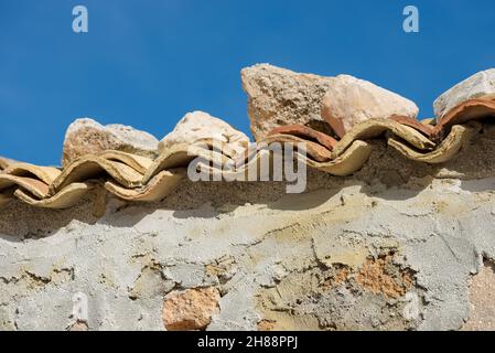 Nahaufnahme einer Steinmauer mit Dachziegeln aus Terrakotta (Pantile), Sizilien, Italien, Europa. Stockfoto