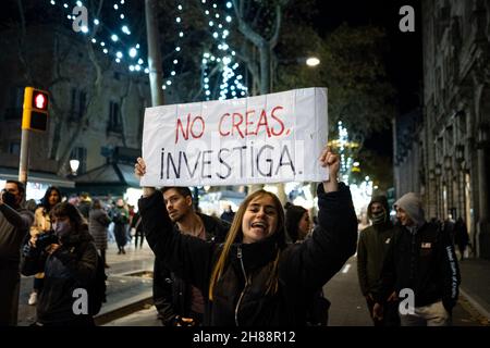 Spanien. 27th. November 2021. In diesem Nahaufnahme-Porträt wird eine junge Frau lächelnd gesehen, während sie am 27. November 2021 in der Straße Ramblas in Barcelona, Spanien, ein Plakat mit der Aufschrift „Glauben Sie nicht, recherchieren“ hält, während sie gegen den Impfpass für Zwangsgeimpfungen protestierte, der als „Grüner Pass“ bekannt ist. Nach der Einführung des Covid-Passes in der Region Katalonien, der unter anderem für den Zugang zu Bars und Restaurants vorgeschrieben sein wird, nahmen rund 400 Menschen an der demonstration Teil. (Foto von Davide Bonaldo/Sipa USA) Quelle: SIPA USA/Alamy Live News Stockfoto