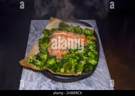 Blick auf rosa Lachs und Brokkoli im Ofen gebacken. Gesundes Lebensmittelkonzept. Schweden. Stockfoto