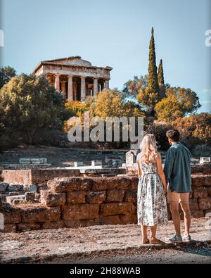 Ein Paar, das den Blick auf die antike Agora von Athen genießt, die sich nordwestlich der Akropolis in der Altstadt von Athen befindet. Stockfoto