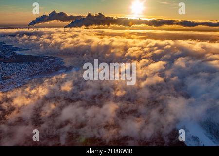Kraftwerk mit ansteigendem Dampf vom Teich zum Himmel in der Wintersaison, Luftaufnahme. Stockfoto