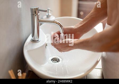 Nahaufnahme eines Mannes, der sich im Badezimmer die Hände wusch Stockfoto