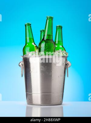 Bierflaschen im Eiskübel. Auf blauem Hintergrund Stockfoto