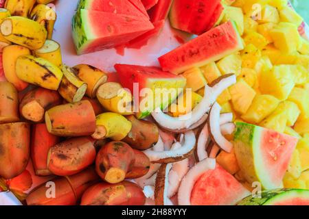 Platte mit geschnittenen tropischen Früchten: Ananas, Bananen, Kokosnuss, Wassermelone Stockfoto