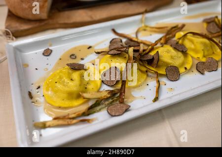 Italienische Küche, frisch hausgemachte rote Kartoffel gefüllte Pasta Tortellacci oder Ravioli Knödel mit sommerlichen schwarzen Trüffeln und knusprigen grünen Spargel, Parma, E Stockfoto