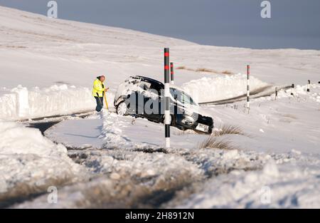 In der Nähe des Buttertubs Pass in North Yorkshire steckte ein Auto in tiefem Schnee. Bilddatum: Sonntag, 28. November 2021. Stockfoto