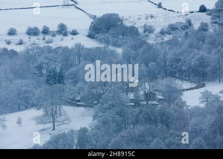 Winterschnee im Shibden-Tal bei Halifax, Calderdale, West Yorkshire, Großbritannien, während die Sonnenuntergänge über den Hügeln. Eine entfernte Shibden Hall das ehemalige Zuhause von Anne Lister, umgeben von Schnee. Stockfoto