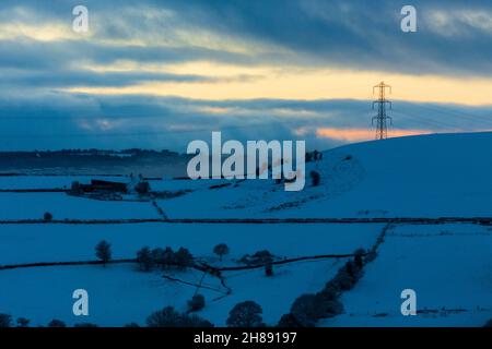 Winterschnee im Shibden-Tal bei Halifax, Calderdale, West Yorkshire, Großbritannien, während die Sonnenuntergänge über den Hügeln. Stockfoto