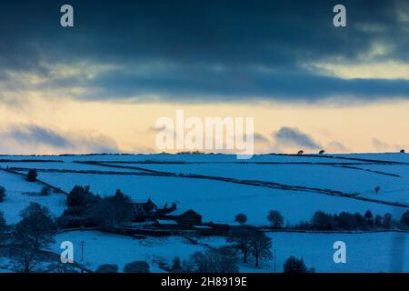 Winterschnee im Shibden-Tal bei Halifax, Calderdale, West Yorkshire, Großbritannien, während die Sonnenuntergänge über den Hügeln. Stockfoto