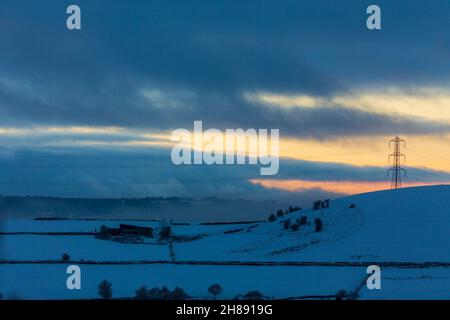 Winterschnee im Shibden-Tal bei Halifax, Calderdale, West Yorkshire, Großbritannien, während die Sonnenuntergänge über den Hügeln. Stockfoto