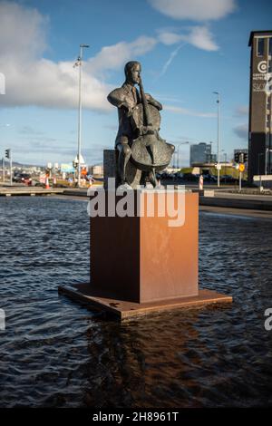 Statue des dänischen Cellisten Erling Blondal Bengtsson vom Bildhauer Olof Palsdottir und die Konzerthalle Harpa in Reykjavik, island Stockfoto