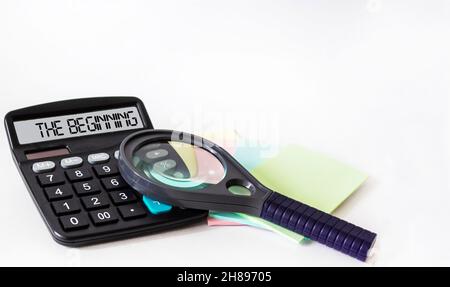 Rechner mit dem Wort, DAS AUF dem Display beginnt. Lupe, Aufkleber auf weißem Hintergrund. Geschäftskonzept Stockfoto