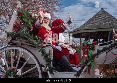 St. Charles, MO – 27. Dezember 2021; Schauspieler und Schauspielerin porträtieren den Weihnachtsmann und Frau Claus, während sie zwei Menschenmengen in einer Pferdekutsche in der Innenstadt von Weihnachten schwenken Stockfoto