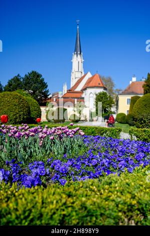 Ein schönes, gepflegtes Blumenbeet mit einer Kirche im Hintergrund. Stockfoto