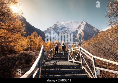 Heiliger Berg Xiannairi, Shangri-La Blick mit Herbstwald an sonnigen Tagen im Yading Naturschutzgebiet, Daocheng, China Stockfoto