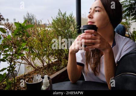Nachdenkliche Frau trinkt Kaffee Stockfoto