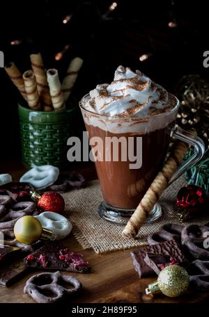 Eine Tasse heiße Schokolade mit Peitschencreme und Kakao darauf bestreut. Stockfoto