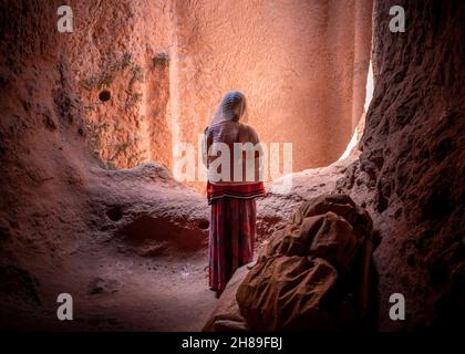 Lalibela, Äthiopien - 23. Mai 2021: Eine verschleierte Frau in traditioneller Kleidung in einer äthiopischen koptischen Kirche Stockfoto