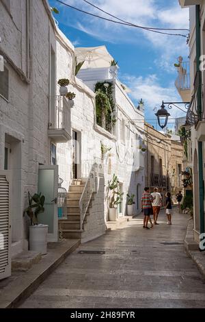 Monopoli, Italien - 20. August 2021: Fußgängerzone in der Altstadt von Monopoli mit Touristen (Apulien) Stockfoto