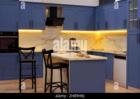 Modernes Küchendesign mit dekorativen Holzdetails und Spotlights im Innenbereich. Stockfoto