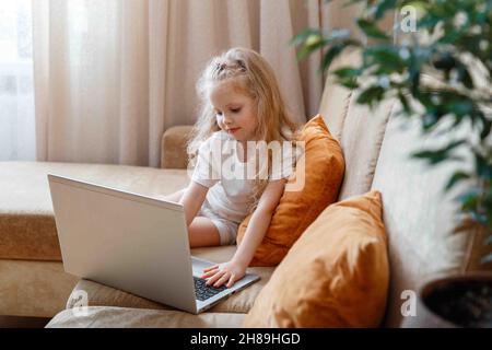 Vorschulkinder Mädchen verwenden Laptop für Fernunterricht in Kindergartenschule. Smart ruhig aufmerksam Mädchen Kind verwenden Laptop für das Ansehen von Video tun Stockfoto