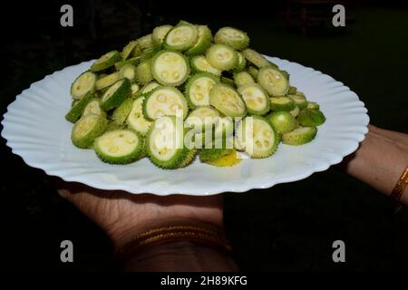 Weibliche Halterungsplatte des Spiny-Kürbis-Gemüses auch bekannt als Wirbelsäulenkürbis oder Kantola sind saisonal gesundes Gemüse, das in Indien Asien angebaut wird und in sli geschnitten wird Stockfoto