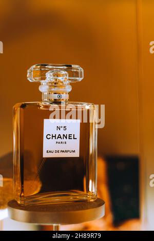 Präsentation der Glasflasche Chanel No. 5 Parfüm der französischen Luxusmarke Chanel vor dem goldenen Hintergrund. Berühmter weiblicher Duft. Stockfoto