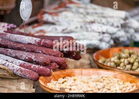 Stapel Chorizo-Würstchen und andere Köstlichkeiten zum Verkauf auf einem Marktstand. Stockfoto